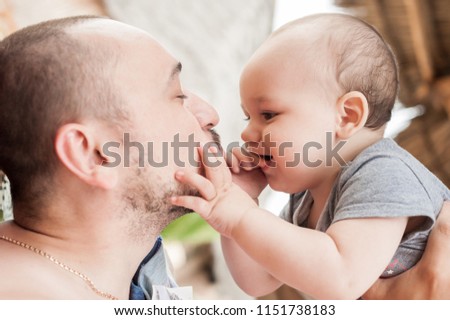 Father and son spend time together. Parent-child relationship. Dad and kid play and hug. Happy family in the sun.