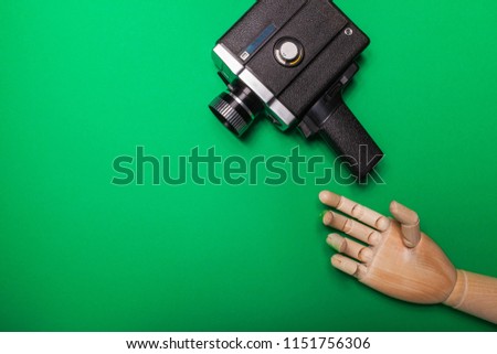 A wooden hand reaches out to the camera on a background of a green background. Video production. Hromakey. Close-up