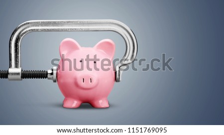 Pink piggy bank and clamp on background Royalty-Free Stock Photo #1151769095