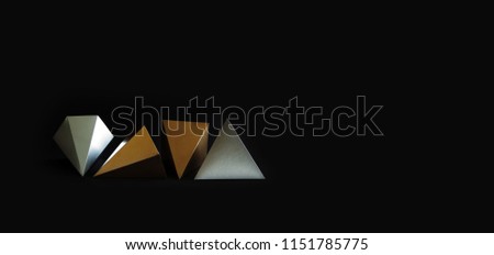 Gold silver minimalistic design geometric solid figures on black. Elegant prism pyramid triangle shape solid objects, paper background. copy space.