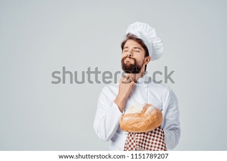 puzzled bearded man holding a loaf of bread in his hand                              