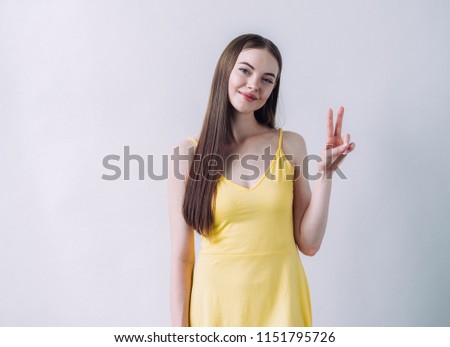 Beautiful brunette with long smooth hair in yellow dress natural portrait over white background