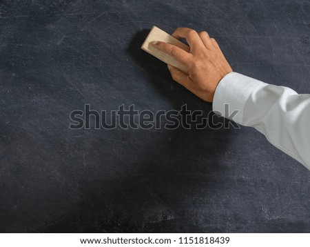 Hand holding brush eraser and blackboard , Concept education and school , background or copy space for add text message.
