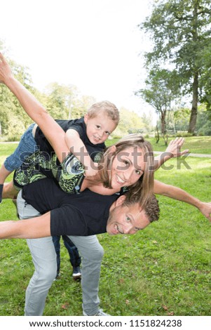 family piggyback with beautiful mother handsome blond father and boy child cheerful