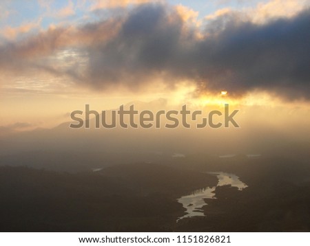 Mystic sunrise in the foggy morning at Munner valley with the Kundala dam lake view far below, Kerala, India.
