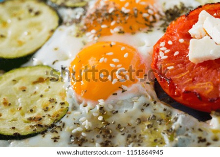 Image of plate with fried eggs with tomatoes and zucchini at plate