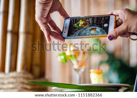 hand of people holding smart phone camera taking shot of food before eating