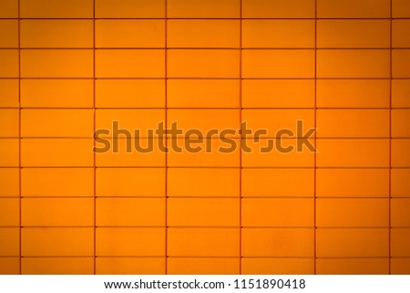 Close-up of a bright orange wall with a geometric rectangular print