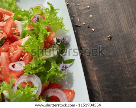 vegetable salad on a white plate, dark background, copy space