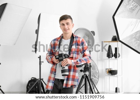 Young male photographer working in studio