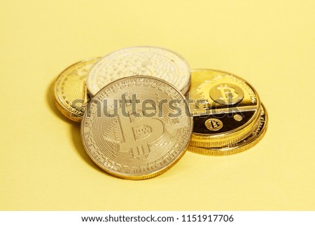 Simple concept image of Cryptocurrency coins on a plain yellow background.