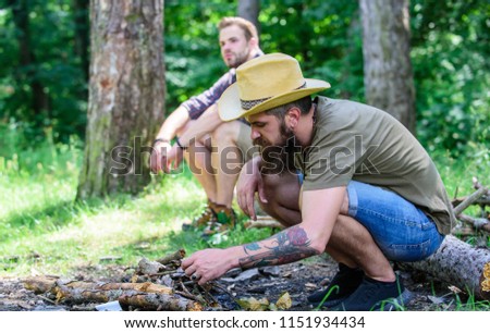 Men on vacation. Masculinity concept. Ultimate guide to bonfires. How to build bonfire outdoors. Arrange the woods twigs or wood sticks. Man brutal bearded hipster prepares bonfire in forest.