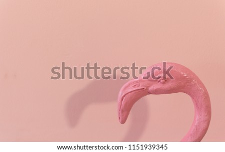 pink flamingo head with its shadow with pink wall
