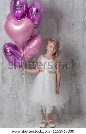 Light hair girl in white dress posing on white wooden background