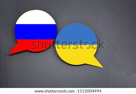 Russia and Ukraine flags with two speech bubbles on dark gray background