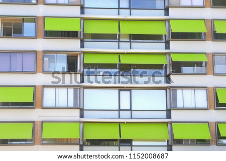Front view of apartment house with lime green awnings, Netherlands.  Protection against sunlight, rising temperatures and heat waves in summer season