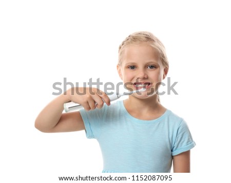 Cute little girl brushing teeth on white background