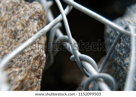 Aluminum wire twisted on stone object, macro background.