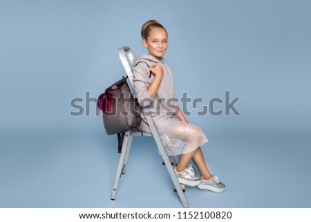 Back to school. Cute child schoolgirl with backpack on blue, pastel background in studio. Girl ready to study - Image