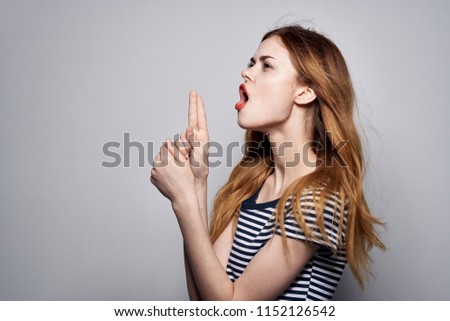 woman with open mouth shows two fingers on hand                            
