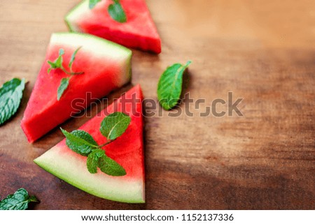 Watermelon slice with mint on rustic wood background. Copyspace.. Flat lay. Summertime concept.
