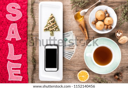 xmas tree wooden table with Christmas new year food, utensils and smartphone with blank screen for app over cooking book on. Top view. Recipe and menu background. flat lay. Mock up. Free copy space.
