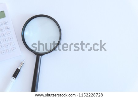Business and finance theme. Copy space of text or logo. Calculator,magnifying glass, and pen isolated on white background.