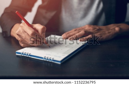 Man hand is write a memo on a calendar