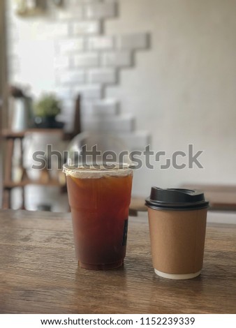 Selective focus of ice coffee with lemon slice and Hot coffee in paper cup. In plastic coffee cup Put on wooden board Put on wooden board. Available space for adding text.