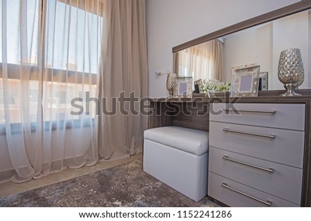 Interior design decor furnishing of luxury show home bedroom with dressing table and window