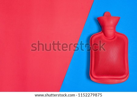 Top view of Hot water bottle or bag isolated on colorful two paper pastel background. Flat lay view.
