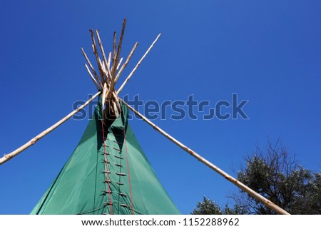  Top of Indian wigwam lodge or teepee against blue sky background. travel concept. copyspace                                                    