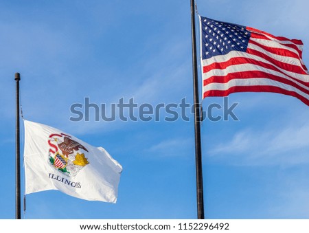 Waving flags of the United States and the state of Illinois with sky in the background