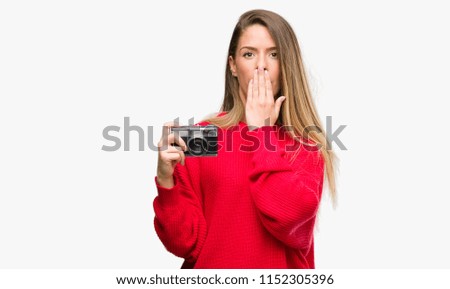 Beautiful young woman holding vintage camera cover mouth with hand shocked with shame for mistake, expression of fear, scared in silence, secret concept