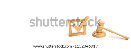 A wooden checkmark and a hammer of the judge on a white background. referendum and elections. Appointment of a judge, election to a constitutional court. Control over the government. copyspace banner