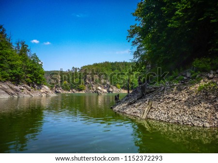 Small cove in blue dam Dalešická přehrada with green forest in beautiful valley in Czech Republic