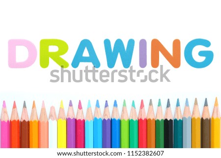 Colored pencils row with alphabet sponge rubber of text "DRAWING" over white background.