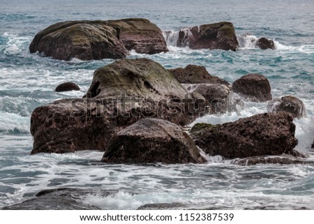 Taiwan East Coast Rocky Coastline Background Image - Pure White Overcast Skies, Exotic Rock Formations in the shape of an ocean wave , Calm Water in the Foreground. Ocean Coastline
