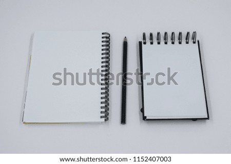 two notepads with a black pencil