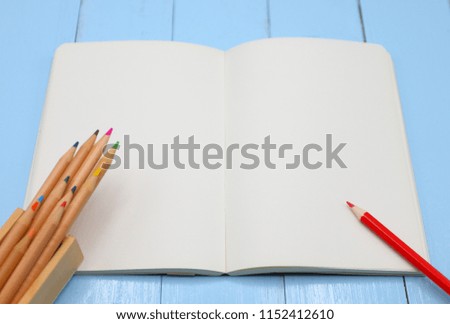 Color pencil on empty notebook plate, education and business concept at top view.