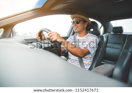 Front view of young asian man driving car. Royalty-Free Stock Photo #1152417671