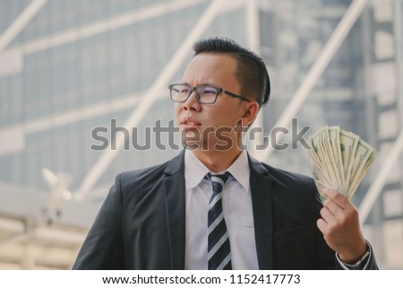 Portrait of happy business man holding cash money dollar bills in his hand. business, people, success and fortune concept
