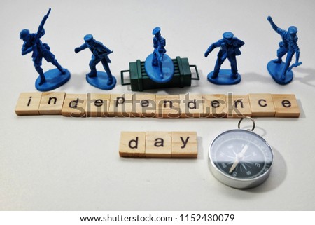A close up picture of army miniature with word tiles creating independence day and compass. Independence is something need to protect by all people.