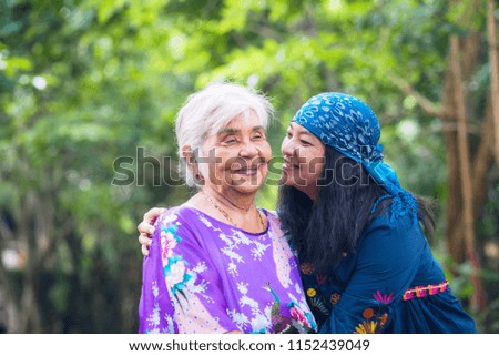 Beautiful senior mom and her adult daughter are hugging,