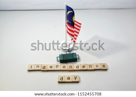 A picture of Malaysia flag with word tiles creating the word independence day which will happen 31st August. Malaysia get its independent from British on 1957.