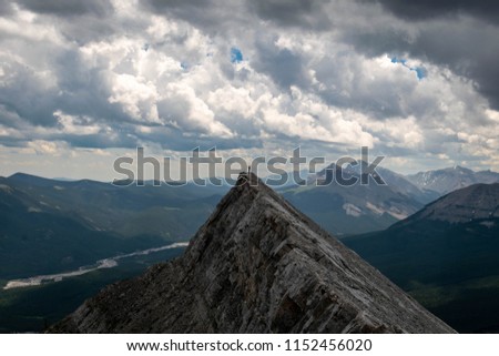 The silhouette of a lone hiker at the top of Nihahi Ridge in Kananaskis, Alberta