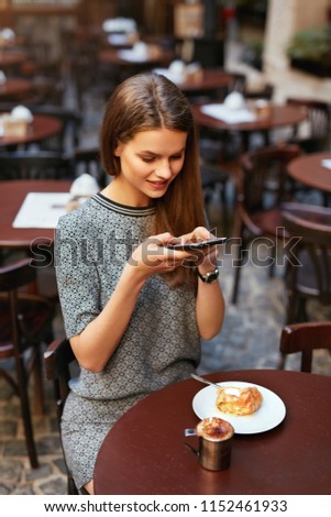 Woman In Cafe Taking Food Photo On Mobile Phone