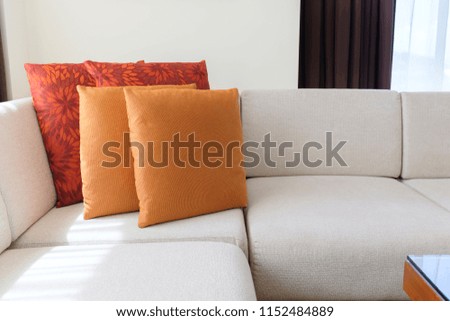 Cozy sofa corner decorated in oriental style with orange and red pillows.