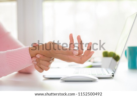 Closeup woman holding her wrist pain from using computer. Office syndrome hand pain by occupational disease. Royalty-Free Stock Photo #1152500492