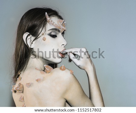 Woman with thorns on back shoulders looks like fantasy creature. Scary fairy tail character. Halloween ideas concept. Girl with thorns devil dragon magical creature. Girl with fantasy style make up.